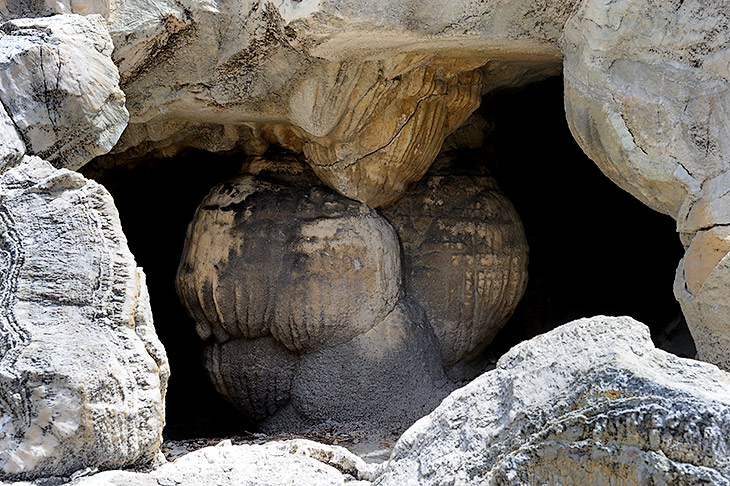 Хитровыгрызенные в скалах пещеры темными дырками смотрят на текущие вокруг струи кипящей воды.
            