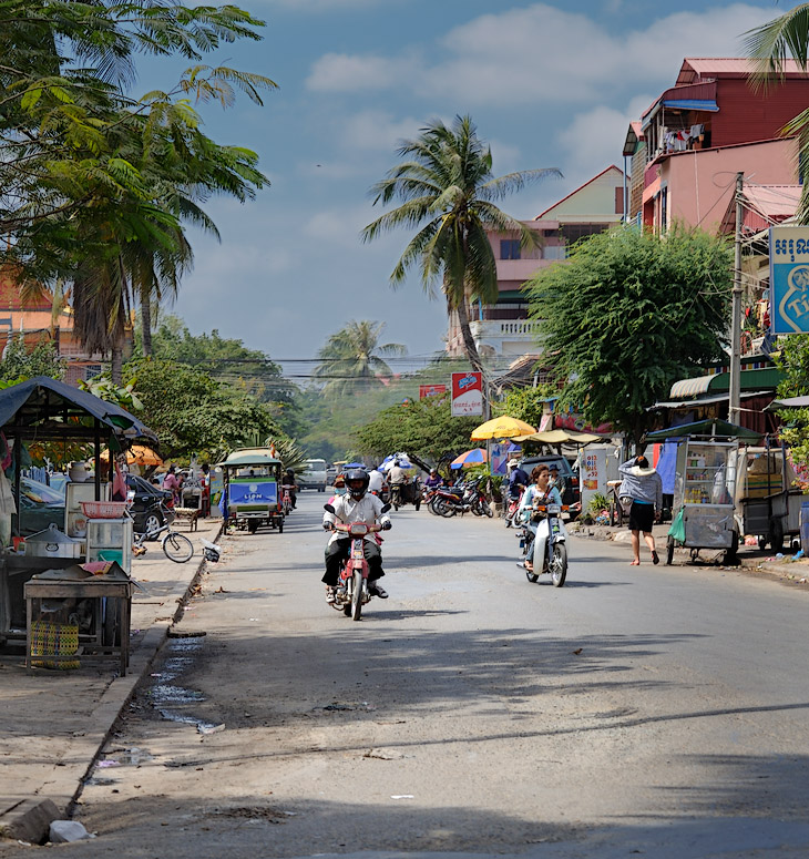 Камбоджийские улицы оснащены тротуарами, правда, заставленными торговыми ларьками и транспортом, но, все же, пригодными для пеших прогулок. Зима тут - сезон засухи, и тучи пыли вздымаются над разбитыми дорогами, особенно в
            пригородах. Впрочем, хватает и широких проспектов с гладким асфальтом. На фоне соседей по ЮВА, кхмеры недостаточно трепетно относятся к вопросам озеленения. Климат ли тому причиной, национальные ли особенности, но жидкая листва над
            головой плохо укрывает прохожих от палящих лучей.