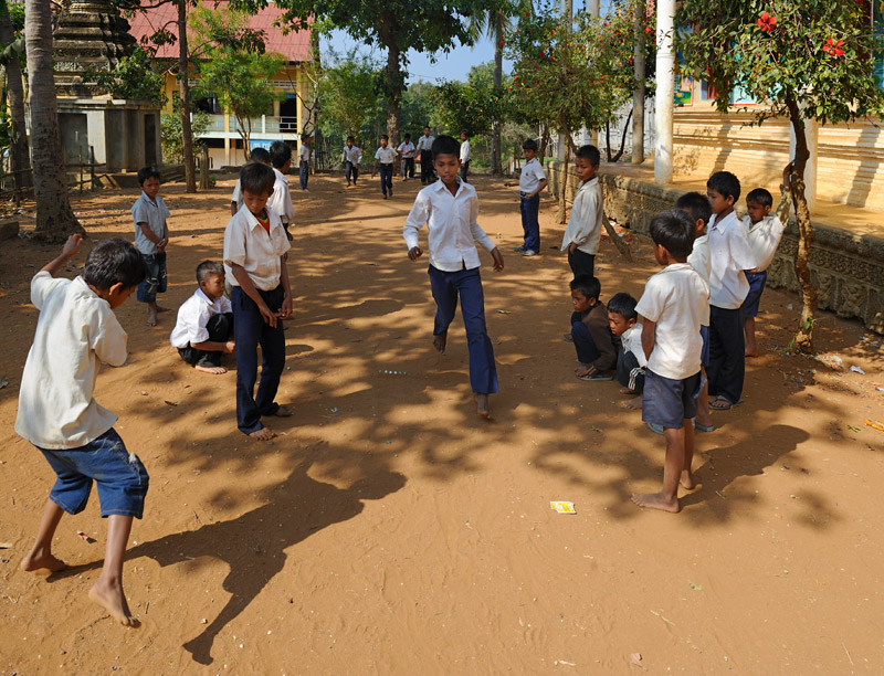 На возвышении расположены храм и школа. Школьники азартно играют в стеклянные шарики.