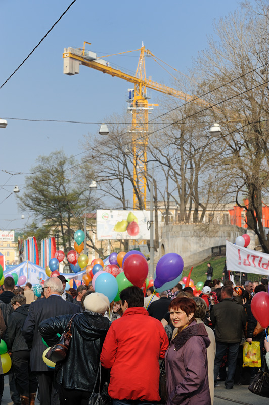 Под сенью раскидистых подъемных кранов, строящих мост через Золотой Рог, толклись неисчислимые участники шествия, согнанные
            твердой рукой правящей партии на коллективное веселье.