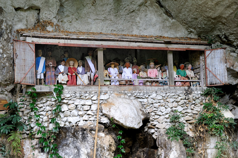 Гробы уносят в пещеру, куклы выставляют отдельно на фасаде.