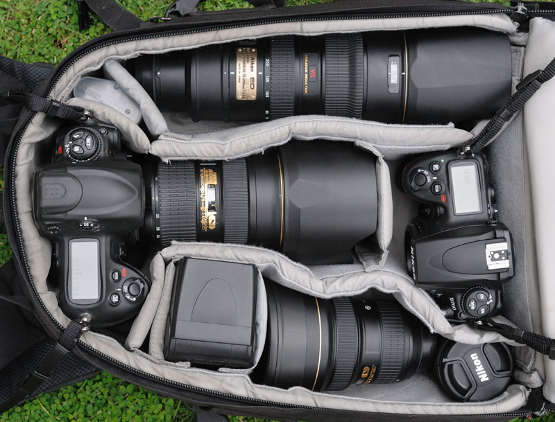 Последние несколько лет внутренности моего рюкзака выглядят примерно таким образом. Набор камер и оптики — результат жесткого «естественного отбора», а не стремление перекрыть весь диапазон фокусных расстояний, или потрясти присутствующих размером объектива. Перепробовав множество вариантов, постепенно остановился на следующем:
Nikon D3 — основная камера.
Nikon D700 — «вторая» камера. Малая высота корпуса, позволяет складывать ее в существующие модели водонепроницаемых Пели-кейсов, что полезно при съемке с воды.
Nikkor 70-200/2.8 — светосильный репортажный «портретник», постоянно конкурирующий у меня с телевиком Nikkor 80-400VR. Возможность съемки при плохом освещении и скорость автофокуса перевешивают большее фокусное расстояние у 80-400. Отмечу, что 70-200/2.8 на открытых дырках сильно виньетирует, что мне нравится, поскольку придает снимкам иллюзию объема.
Nikkor 24-70/2.8 — штатный светосильный зум. Дает относительно резкую, но плоскую и невыразительную картинку. Для моих задач вполне пригоден. На фото видно, как он потерт и потрепан от интенсивного использования.
Nikkor 14-24/2.8 — сверхширокоугольный объектив. Великолепен и в репортаже и в пейзажной съемке, хотя как все сверхширики требует аккуратности в выборе композиции и чувства меры. Несмотря на нещадную эксплуатацию в самых антисанитарных условиях, на работоспособности это никак не отражается и опасения по поводу сильно торчащей выпуклой передней линзы напрасны.
Nikkor 20/2.8 — «затычка» для Nikon D700. Используется для съемок с воды из каяка. Весьма неплох оптически, при крохотных размерах.
Вместо Nikоn D700 + 20/2.8, многие съемки из каяка сделаны на Nikon D300 + 35/2. Прежние ракурсы приелись и сейчас хочется более широкого угла.
Вспышка SB800 — поскольку со вспышкой я снимаю исключительно редко, основное достоинство данной модели — малый вес и габариты. Питание вспышки осуществляю от четырех литиевых одноразовых батарей формата АА, ставить пятую батарею нет необходимости, скорость перезарядки и без того избыточна. Я не использую перезаряжаемые аккумуляторы по причине их большого веса и сильного саморазряда.
Светофильтры — на 70-200/2.8 и 27-70/2.8 стоят защитные светофильтры Кенко (такие попались в продаже). На этих двух объективах я никогда не использую крышки, ни при переноске, ни при эксплуатации. Для защиты передней линзы хватает всегда надетой бленды и светофильтра (на всякий случай).
Я не пользуюсь цветными, градиентными, нейтральными и поляризованными светофильтрами. Как-то не прижились.
Карты памяти — только Сандиск. Раньше использовал медленные по 16 Гб, сейчас перешел на быстрые по 32 Гб.
Штатив или монопод с данным комплектом не использую.
 
